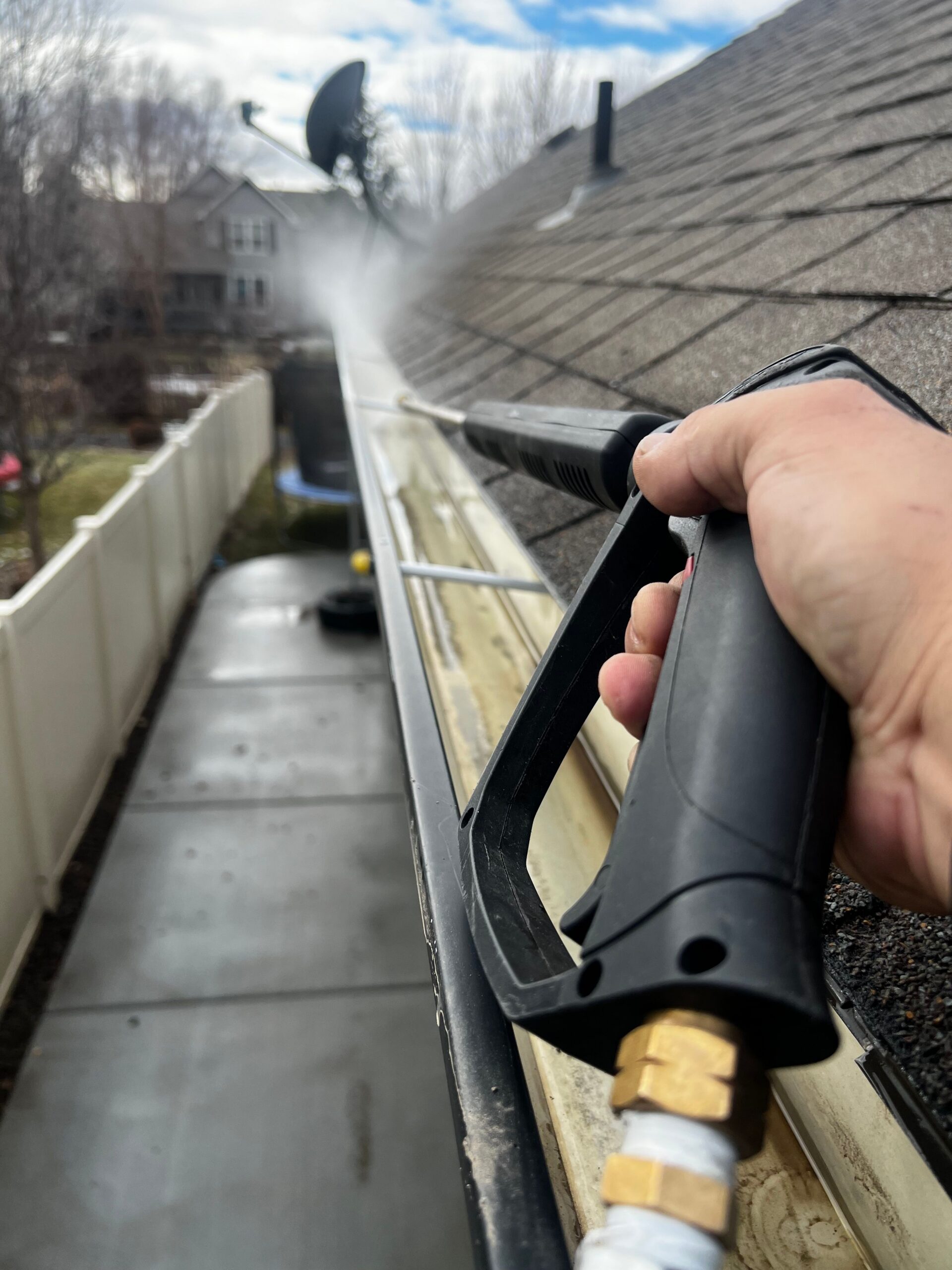 Pressure washing and cleaning out a clogged roof gutter on a Nashville TN home